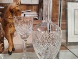 three glass vases on a glass table with a horse figurine in the background