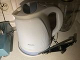 a white electric kettle sitting on a counter next to a blender and a blender
