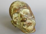 a ceramic sculpture of a man ' s face on a table