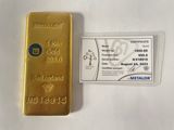 le lingot d'or se trouve à côté d'une carte d'identité métallique, posés sur une surface blanche