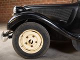 a black car parked in a garage with a brick wall behind it