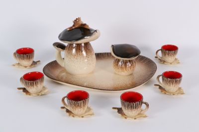 Plusieurs tasses et soucoupes sont disposées sur un plateau, avec une soucoupe au milieu.