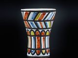 un gros plan d'un vase coloré posé sur une surface noire