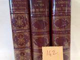 quatre vieux livres sont empilés les uns sur les autres, avec une étiquette de prix