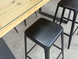 four stools sitting at a table with a glass top