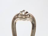 a silver plate with a silver handle on a table
