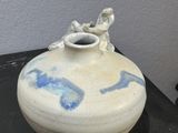a white vase with blue designs on it sitting on a table