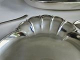 a silver plate with a spoon and a spoon rest on a table