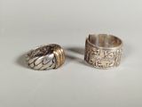 two silver rings sitting on top of each other on top of a table