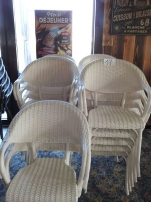 trois chaises en osier blanc et un repose-pieds dans une pièce