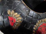 un vase noir orné d'une rose rouge