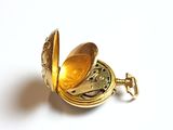 a gold colored pocket watch with a gold colored face