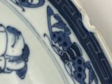 a blue and white plate with a picture of a man riding a horse