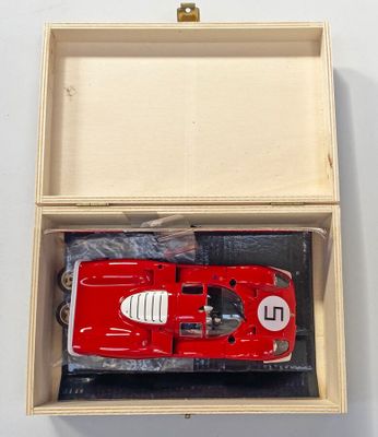 une maquette rouge d'une voiture de course dans une boîte en bois