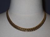 a close up of a gold chain necklace on a mannequin