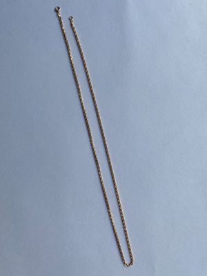 un collier avec une chaîne en or sur fond bleu