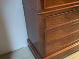 a wooden dresser with a marble top in a room