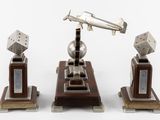 three metal objects sitting on top of a wooden stand