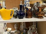 de nombreux vases et assiettes posés sur une étagère dans une pièce