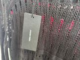 the back of a gray sweater with a tag on it