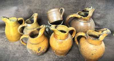 five brown vases sitting next to each other on a table