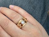 la main d'une femme à laquelle est enfilée une bague en or