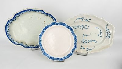 three blue and white plates sitting next to each other on a white surface