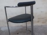 a black chair with a black seat on a concrete floor