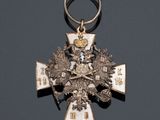 a silver and gold medal with a cross on it