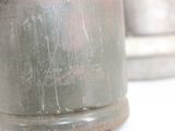 a close up of a metal vase on a table