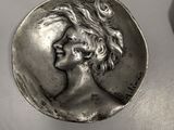 an image of a silver coin with a woman ' s face on it