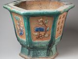 a green planter with flowers and birds on it