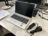 un ordinateur portable posé sur un bureau, à côté d'un écran