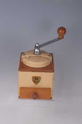 a small coffee grinder sitting on a white surface