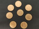 un groupe de six pièces d'or posées sur une surface noire