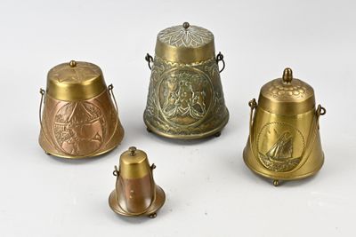 four antique brass bells are sitting on a white surface