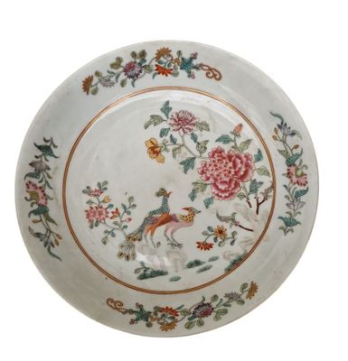 une assiette blanche décorée d'un oiseau et de fleurs