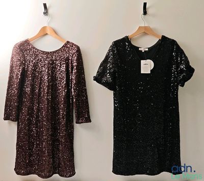 deux robes pour femmes suspendues à un mur à l'aide de cintres