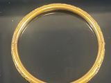 un gros plan d'un bracelet en or sur une surface noire
