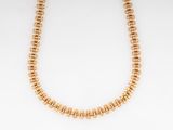 a gold beaded necklace on a white background