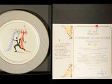 une assiette sur laquelle est représenté un homme et une femme tenant une raquette de tennis