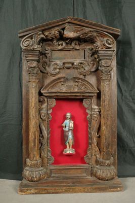 statue d'un homme dans un cadre en bois sur fond rouge