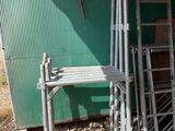 a stack of ladders next to a green building
