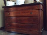 une commode en bois sur laquelle sont posées trois tasses