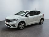 Une voiture blanche est garée dans une pièce blanche au sol noir.