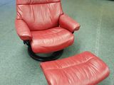 un fauteuil inclinable en cuir rouge et un repose-pieds dans une pièce