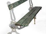 a green park bench sitting on top of a white floor