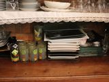 many plates and glasses on a shelf in the kitchen
