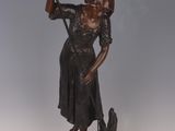 bronze statue of a woman holding a gun and a bird