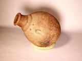 a brown vase with a face on it sitting on a white surface
